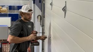 Stapley Action Garage Door technician repairing a garage door in Mesa, AZ
