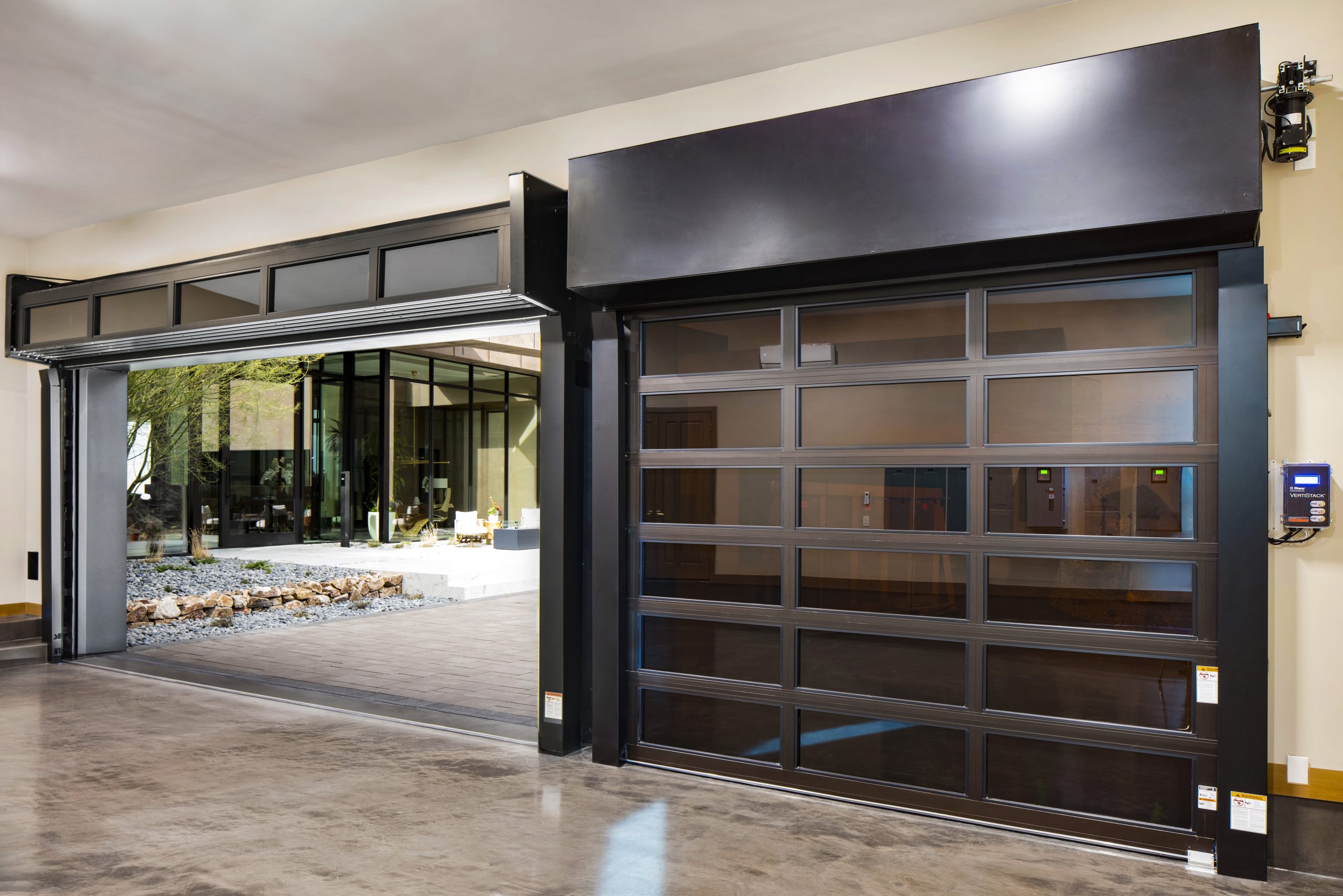Clopay Avante VertiStack full-view glass garage door in a modern luxury home